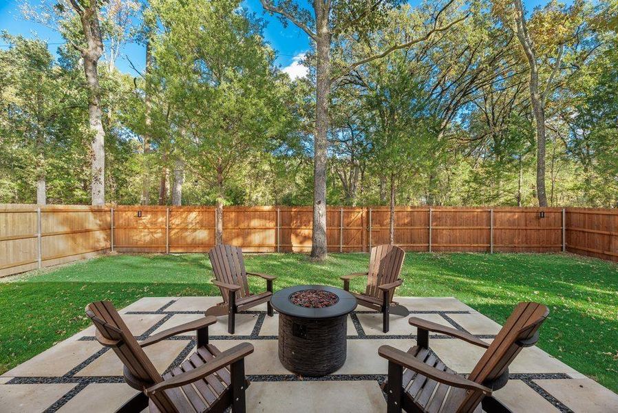Fenced backyard featuring a fire pit and a patio
