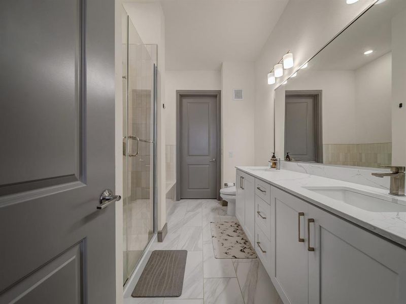 Bathroom with double vanity, a shower stall, and light marble finish floors Bathroom with double vanity, a shower stall, and light marble finish floors