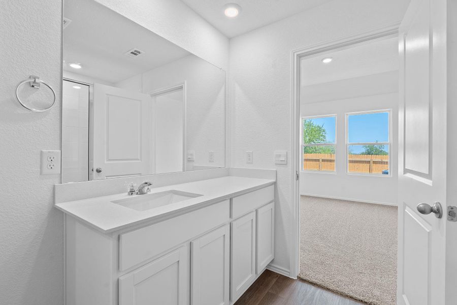 Bathroom featuring vanity, dark wood-type flooring, recessed lighting, and a textured wall Bathroom featuring vanity, dark wood-type flooring, recessed lighting, and a textured wall