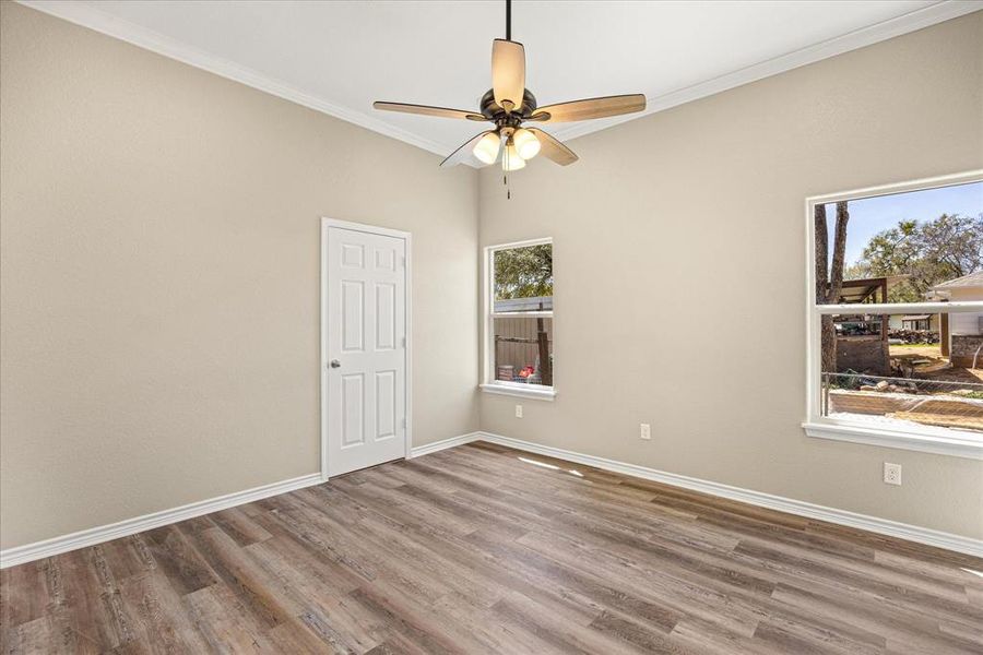Unfurnished room featuring wood finished floors, ceiling fan, and ornamental molding