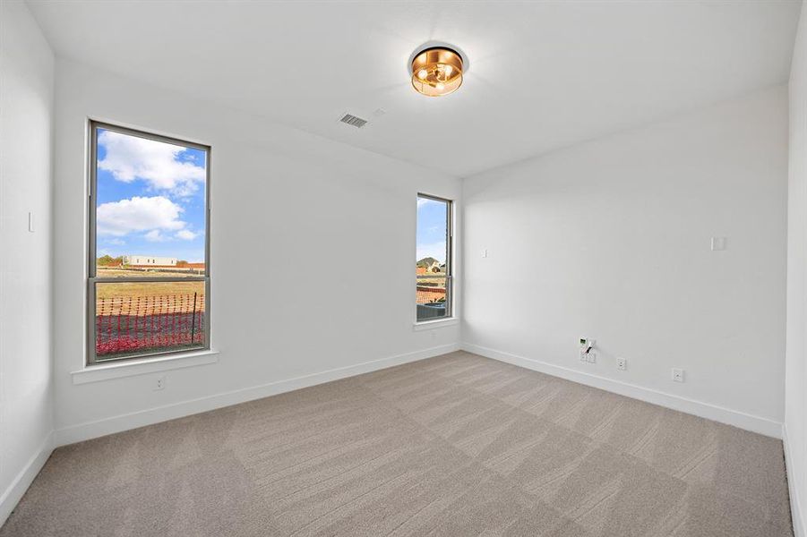 Spare room featuring light colored carpet and baseboards