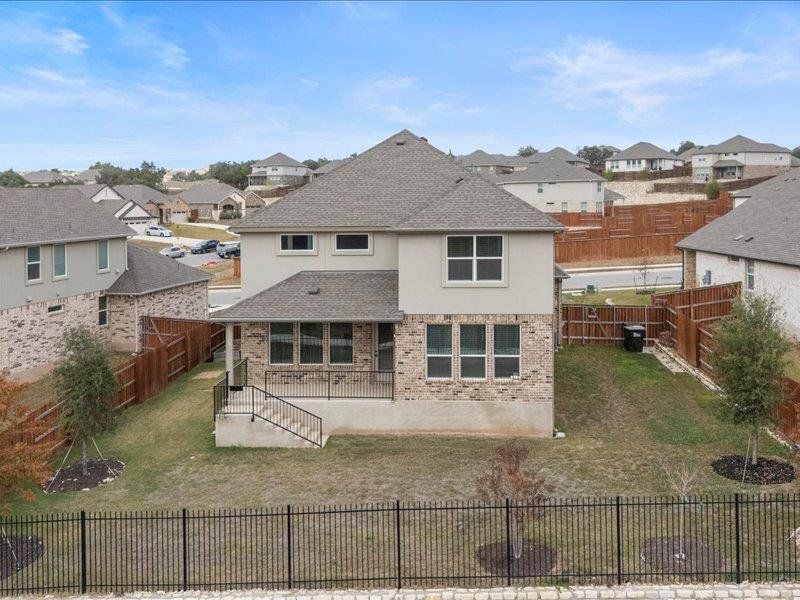 Rear view of property featuring a residential view, a patio, and a fenced backyard