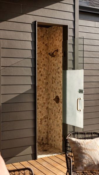 An outdoor shower features pebble tile and is great place to rinse off An outdoor shower features pebble tile and is great place to rinse off