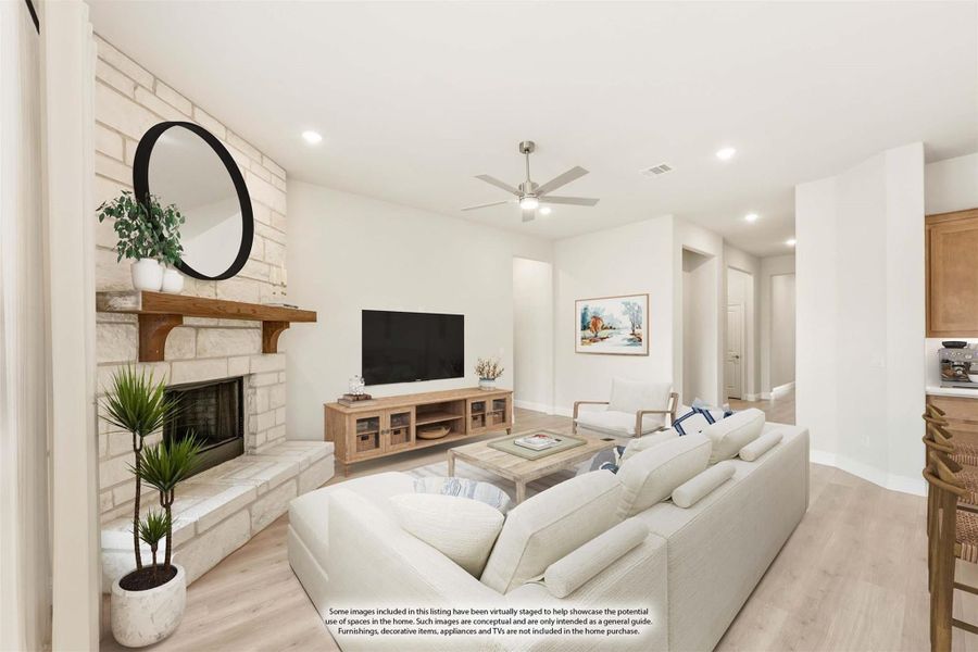 Living room with stone fireplace, ceiling fan, light wood floors, and white sectional sofa Living room with stone fireplace, ceiling fan, light wood floors, and white sectional sofa
