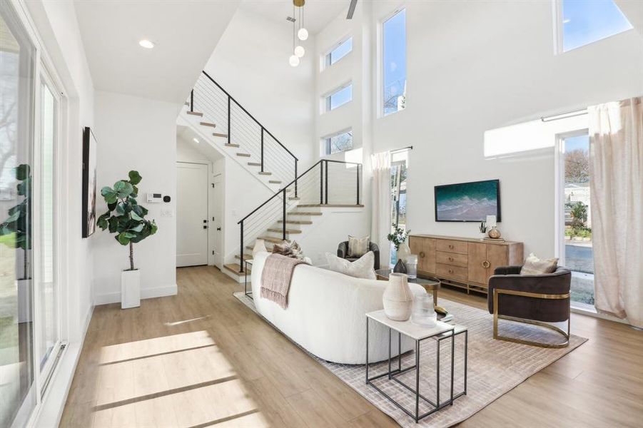 Living room featuring a high ceiling and light hardwood / wood-style flooring