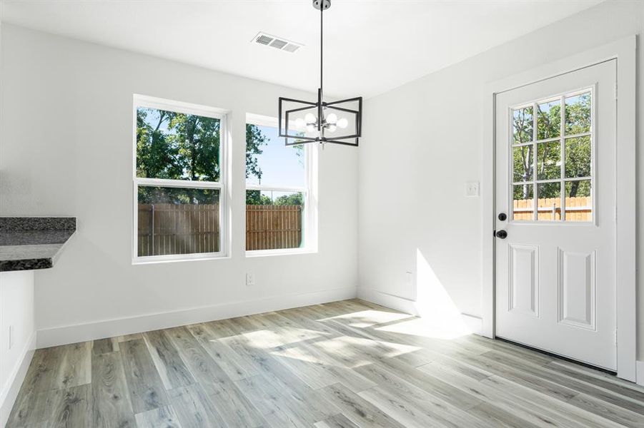 Unfurnished dining area with light wood-type flooring and a chandelier