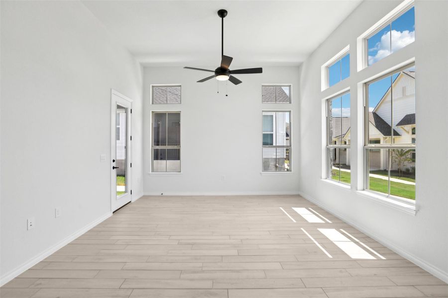 Unfurnished sunroom featuring baseboards and wood finished floors