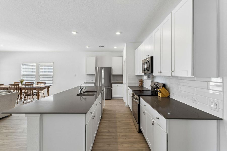 An open concept kitchen features abundant counter space and integrated appliances for modern living.