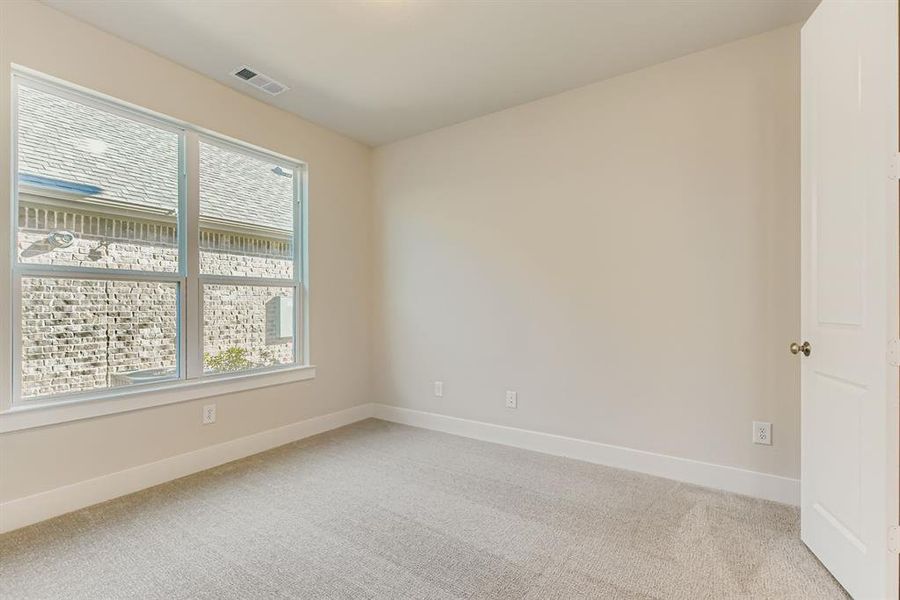Empty room featuring light carpet and baseboards