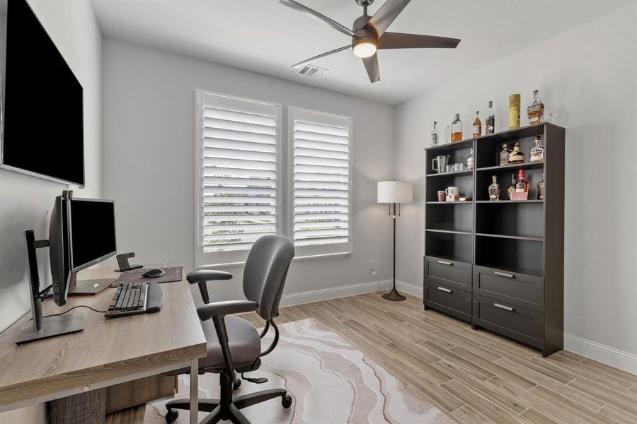Home office with a ceiling fan and light wood finished floors