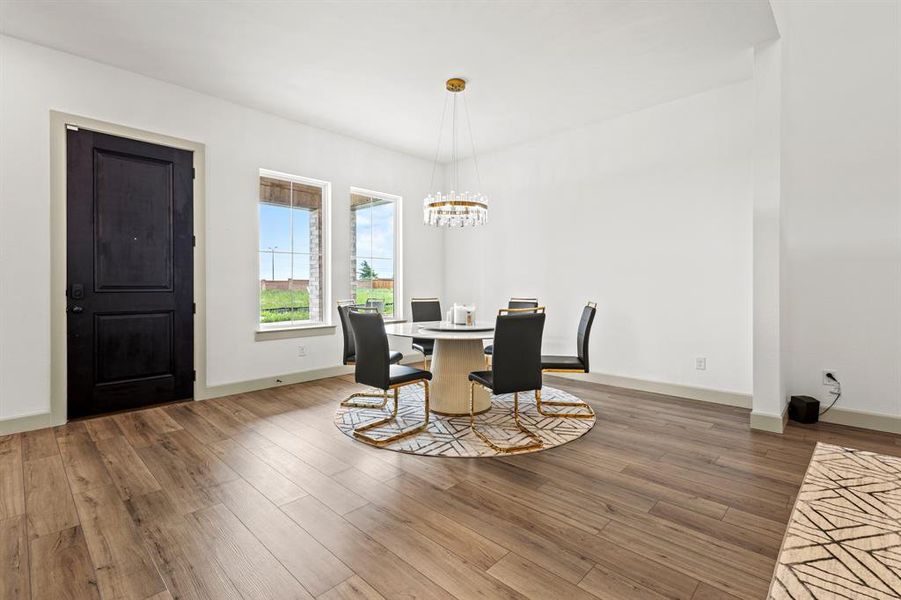 Dining area with wood finished floors and a chandelier