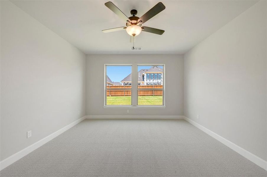 Spacious room featuring neutral carpeting, light-toned wall paint, and white baseboards