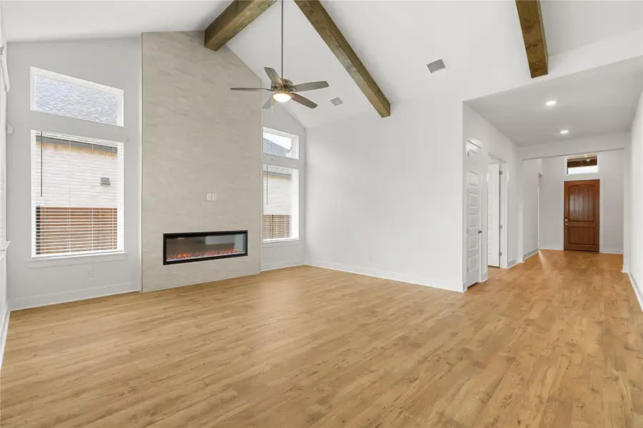 A spacious living area with soaring vaulted ceilings, wood flooring, and an elegant fireplace creates an inviting atmosphere. A spacious living area with soaring vaulted ceilings, wood flooring, and an elegant fireplace creates an inviting atmosphere.