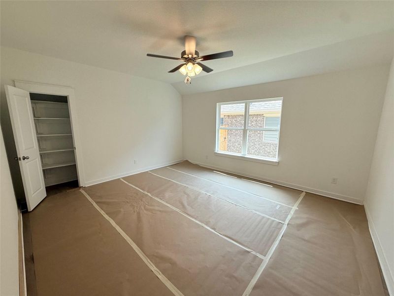 Unfurnished bedroom featuring a ceiling fan and a walk in closet Unfurnished bedroom featuring a ceiling fan and a walk in closet
