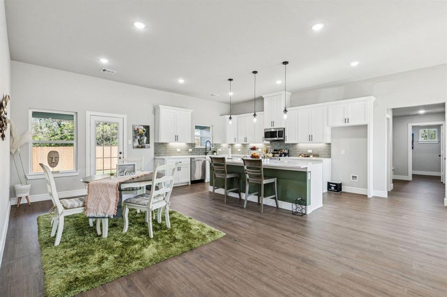 Dining space with plenty of natural light, recessed lighting, and dark wood finished floors