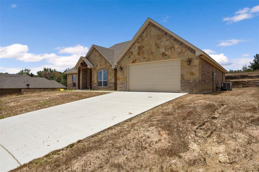 View of front of property with central AC and a garage