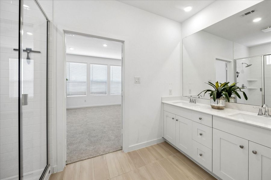 Morning routines feel a little easier with plenty of counter space, dual sinks and storage to spare, while the glass enclosed shower and clean neutral finishes keep the owner’s bath feeling fresh and relaxing.