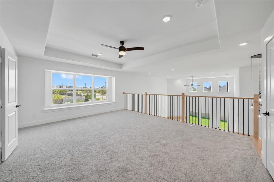 Unfurnished room with ceiling fan, a raised ceiling, plenty of natural light, and recessed lighting
