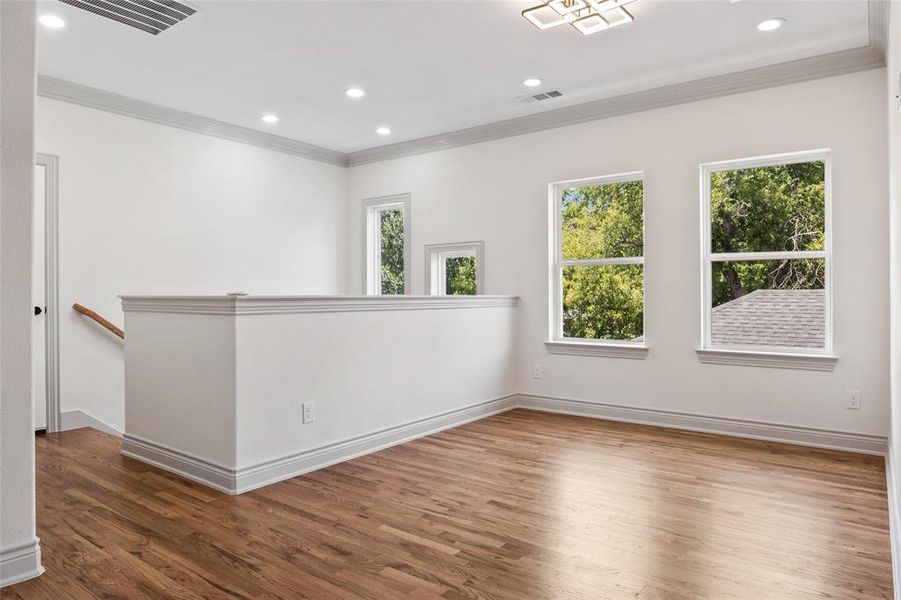 Game room featuring crown molding, hardwood finished floors, and recessed lighting Game room featuring crown molding, hardwood finished floors, and recessed lighting