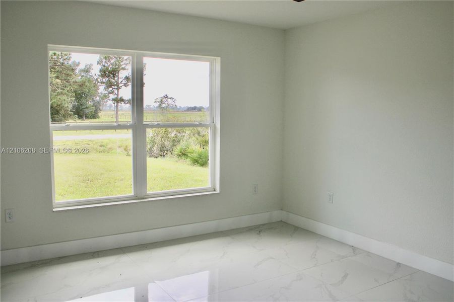 Neutral-toned interior featuring large-format tile flooring and a double-pane window