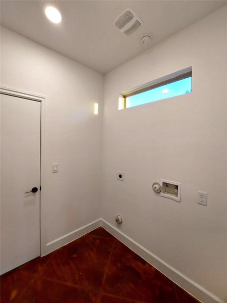 Laundry room with  high window above the washer and dryer connections recessed lighting in the laundry room as well.