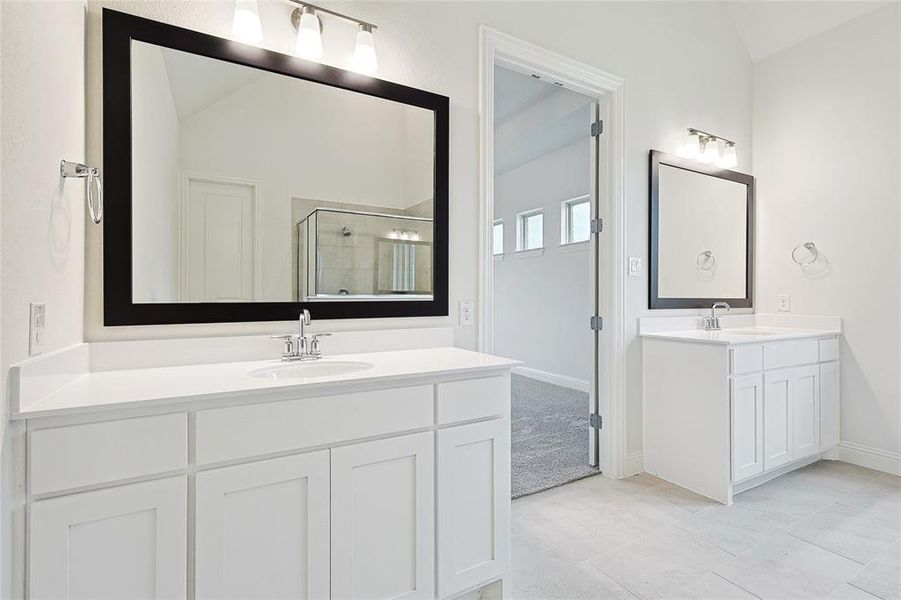 Bathroom with lofted ceiling, a shower with door, and vanity