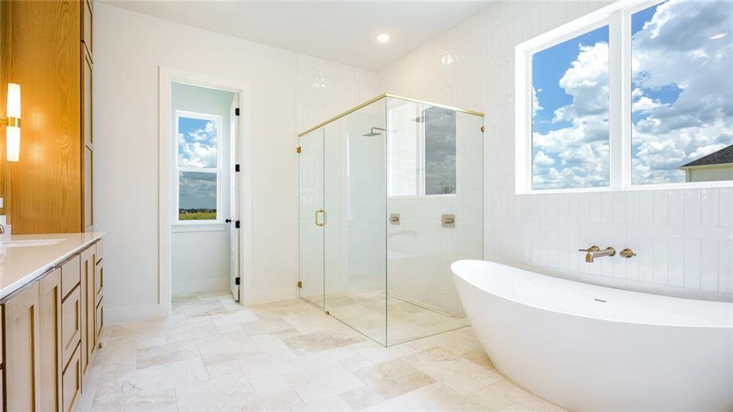 Bathroom featuring tile walls, tile flooring, shower with separate bathtub, and vanity