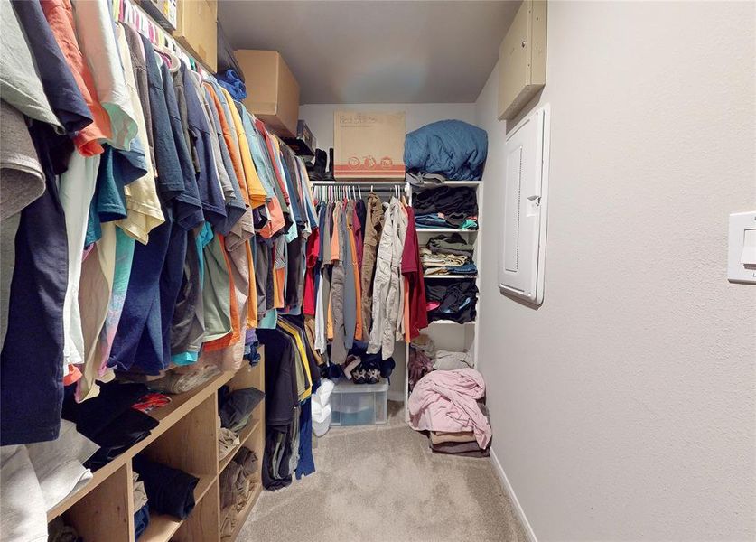 Spacious walk-in closet with ample hanging space and shelving for organized storage. Ideal for maximizing clothing and accessory organization.