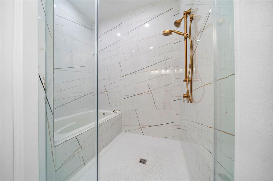 The large glass shower with striking modern tile, a soaking tub and rain showerhead.