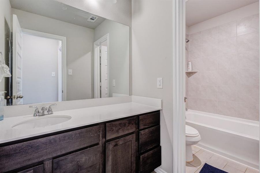 Bathroom featuring shower combination, vanity, and light tile patterned floors Bathroom featuring shower combination, vanity, and light tile patterned floors