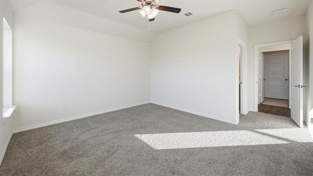 Spacious room featuring gray carpet, a ceiling fan, and a window with a deep sill