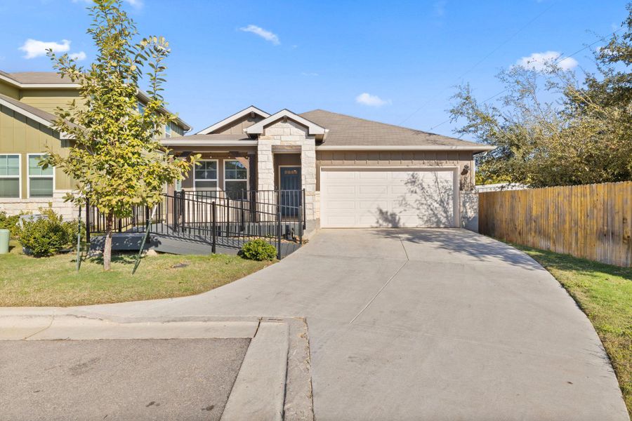 Ranch-style home featuring stone siding, driveway, an attached garage, and a porch Ranch-style home featuring stone siding, driveway, an attached garage, and a porch