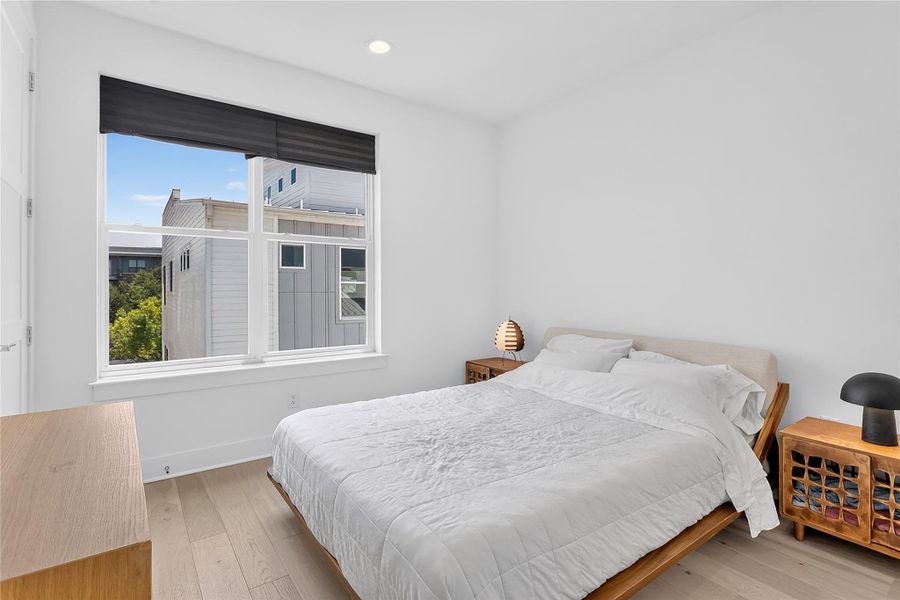 Bright and airy, this bedroom provides a tranquil retreat with wide plank hardwood floors and a large window overlooking the neighborhood.