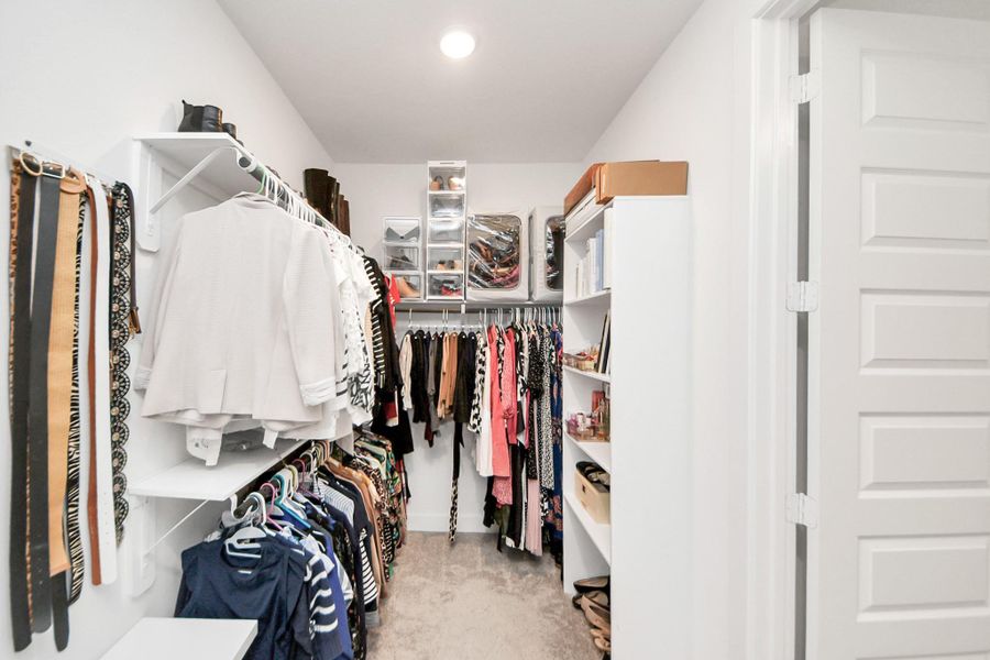 Spacious primary walk-in closet with double hanging and shelving.