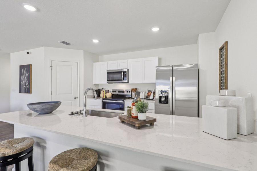 A kitchen with white cabinets.