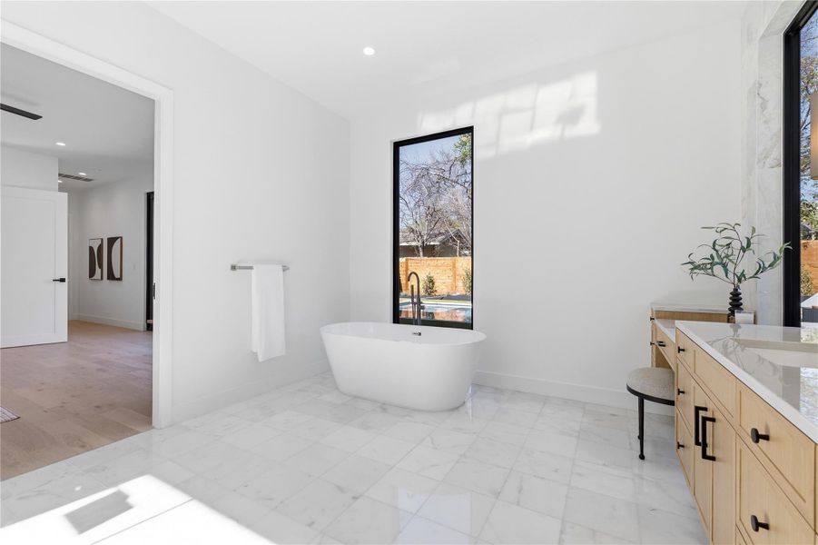 Bathroom featuring vanity, a freestanding tub, and recessed lighting