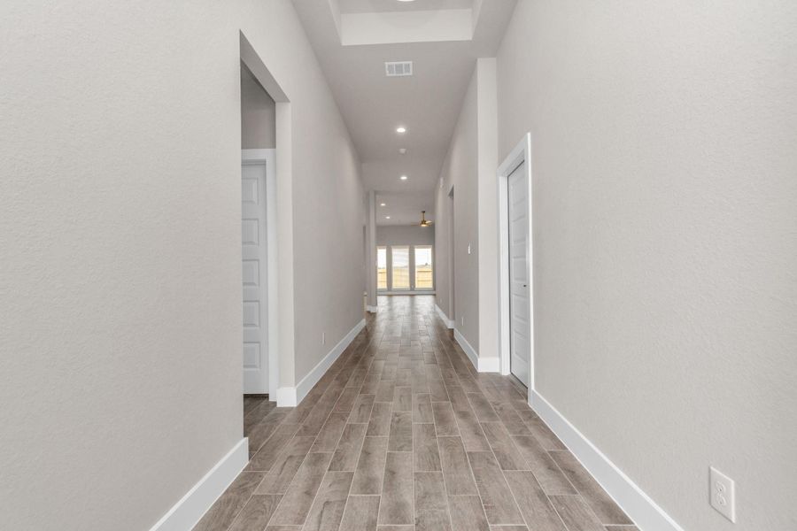 The majestic entryway allures with its high ceilings, embellished with sophisticated wood-look tile flooring and sleek oversized baseboards. Sample photo of completed home with similar floor plan. Actual colors and selections may vary. The majestic entryway allures with its high ceilings, embellished with sophisticated wood-look tile flooring and sleek oversized baseboards. Sample photo of completed home with similar floor plan. Actual colors and selections may vary.
