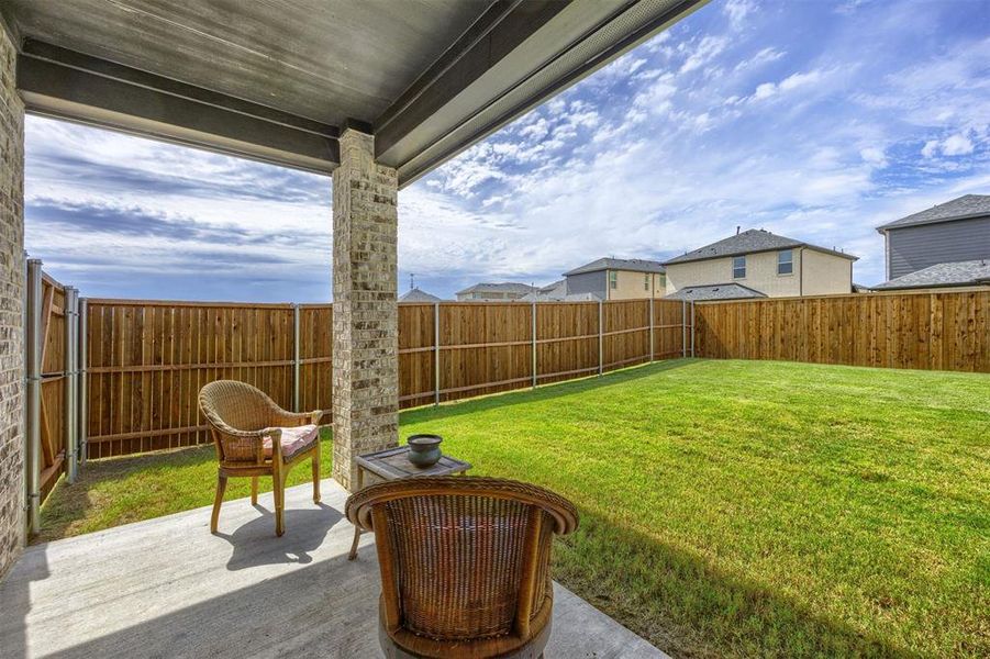 Covered patio featuring concrete flooring and brick support columns
