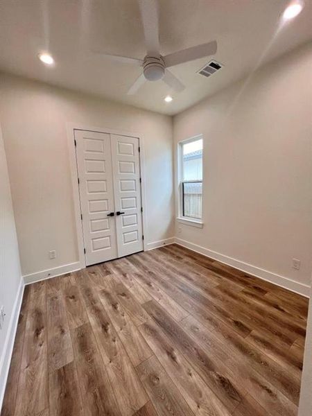 A bright white room featuring wooden floors and elegant white doors, creating a clean and spacious atmosphere .