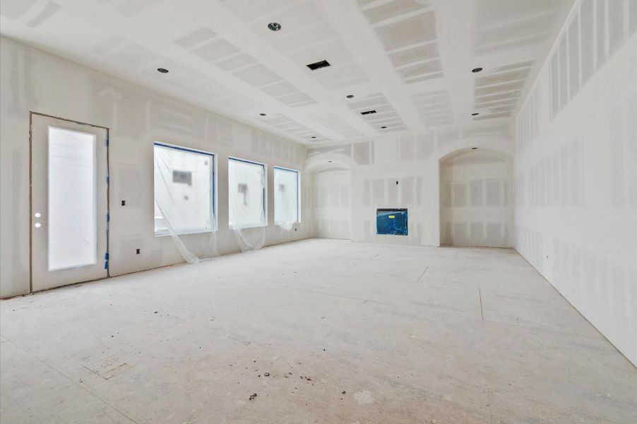 Spacious living area with 11-foot ceilings, two beautiful arches, and planned white oak cabinetry with floating shelves.