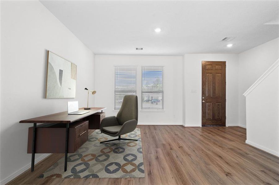 The front living room space can be used for your specific needs. Here it's featured as an office and it offers plenty of natural light with the windows and privacy blinds, recessed lighting, and gorgeous tile flooring!