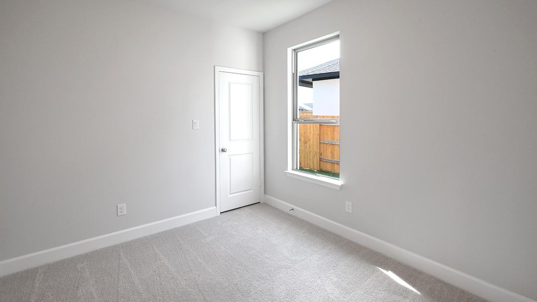 Unfurnished room featuring baseboards and light carpet
