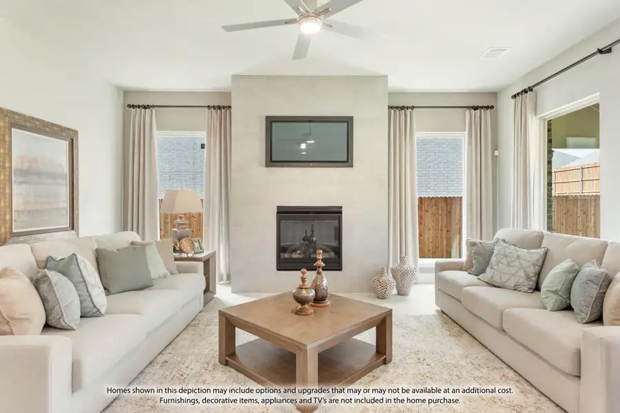 Living room with two beige sofas, floor-to-ceiling fireplace, wall-mounted TV, and ceiling fan Living room with two beige sofas, floor-to-ceiling fireplace, wall-mounted TV, and ceiling fan