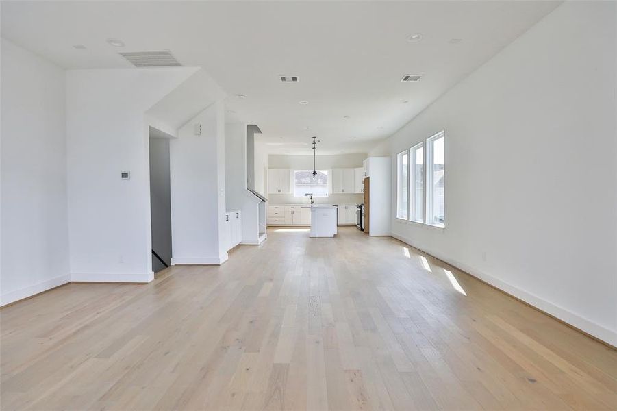 Large windows fill this open living room with natural light, creating a bright and welcoming atmosphere.