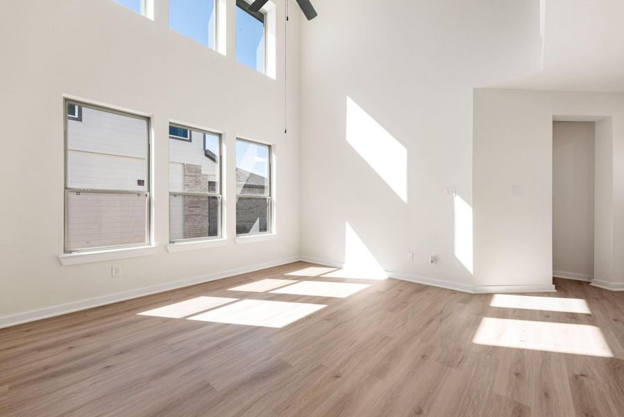 The expansive living room is bathed in abundant natural light! Featuring wide-plank flooring and a large, dark ceiling fan centered high in the vaulted space, adding a focal point and aiding air circulation. A welcoming space perfect for relaxation and everyday living. The expansive living room is bathed in abundant natural light! Featuring wide-plank flooring and a large, dark ceiling fan centered high in the vaulted space, adding a focal point and aiding air circulation. A welcoming space perfect for relaxation and everyday living.