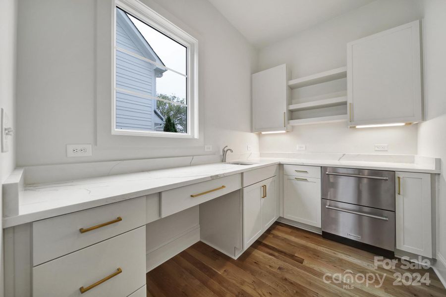 Scullery off of the kitchen with ample counter space, additional cabinets, and beverage fridge.