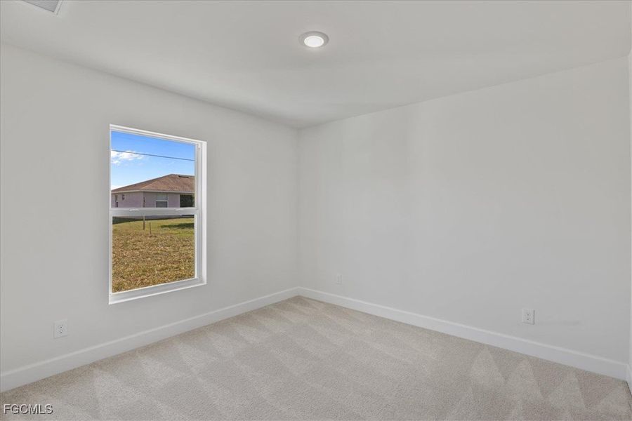 Spare room with light carpet and baseboards