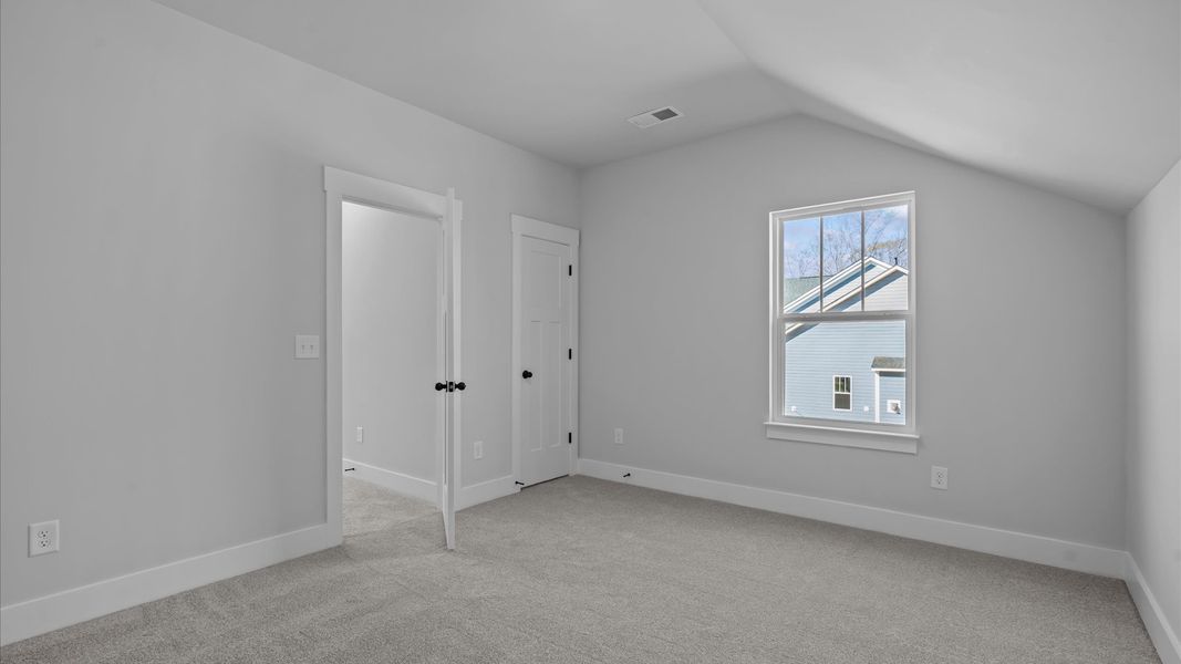 Notable bedroom offering soft carpet, a walk-in closet, and expansive windows