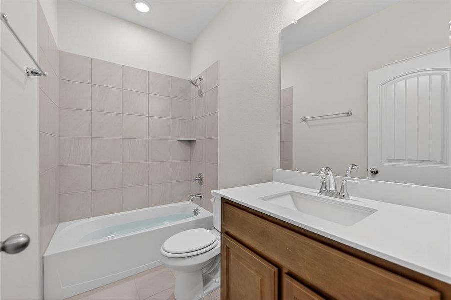 Bathroom with shower / washtub combination, vanity, and light tile patterned flooring