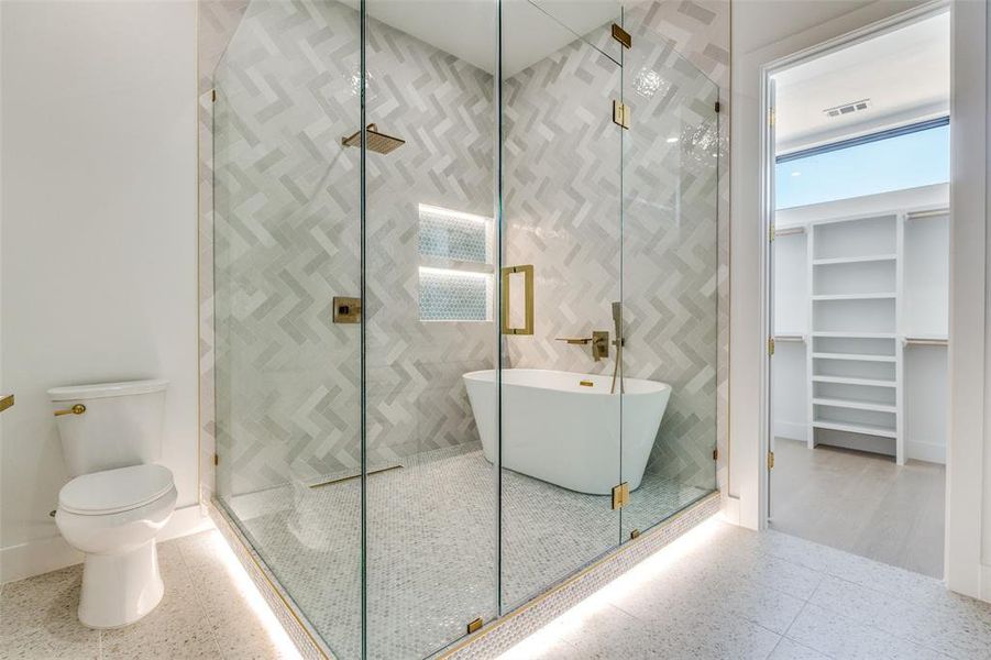 Full bath featuring a shower stall, a spacious closet, and a soaking tub